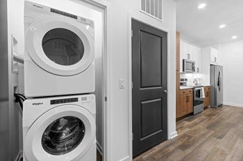 A white Whirlpool washing machine and dryer in a modern laundry room.